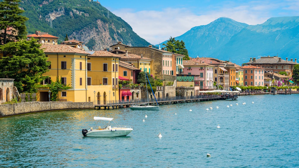 Boot am Gardasee bei Sonnenschein, dahinter ein malerisches Dorf