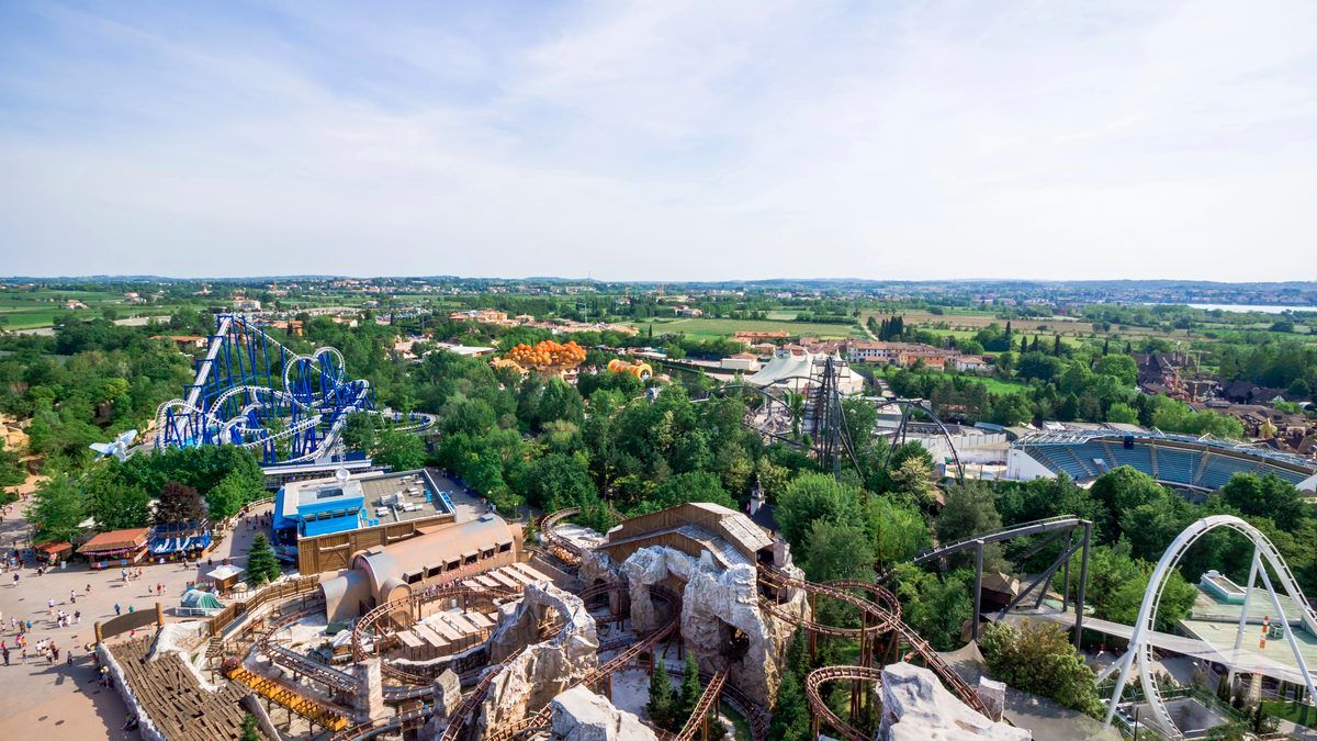 Luftbild über den größten Freizeitpark Italiens bei Castelnuovo del Garda mit mehreren Achterbahnen und dem Hügelland dahinter