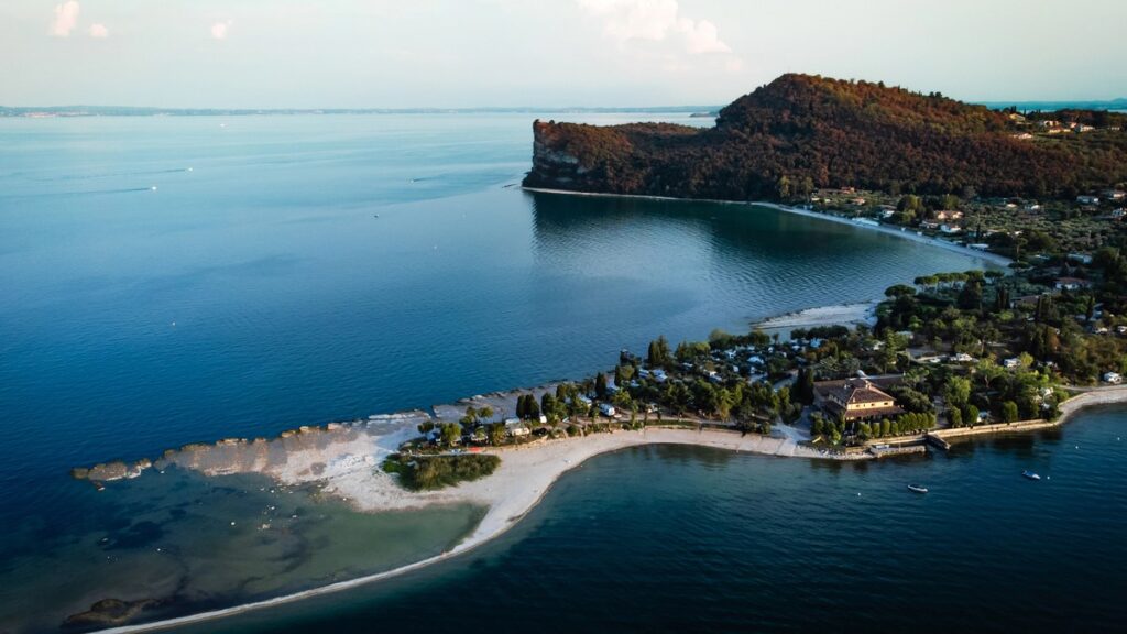 Luftbild der Isola dei Conigli bei Manerba del Garda mit Sandbank, Rocca und türkisem Flachwasser