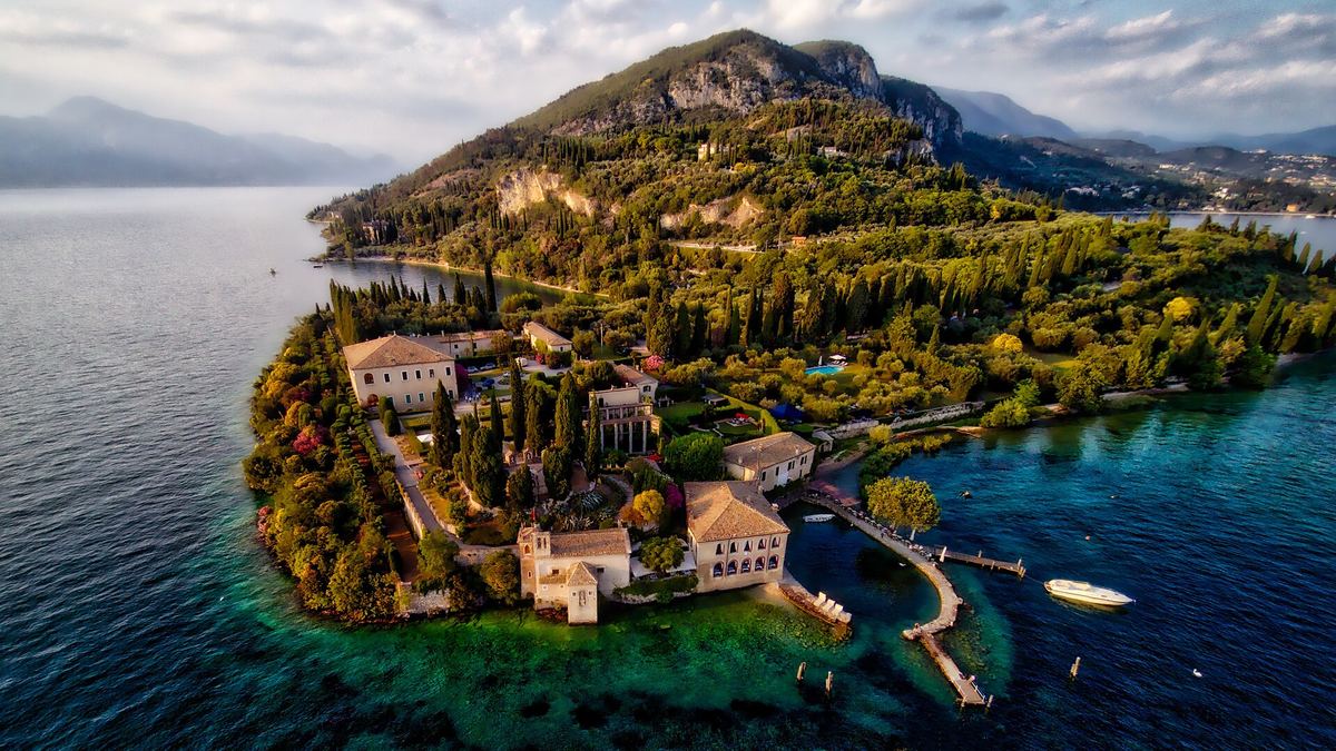 Luftbild der Halbinsel Punta San Vigilio mit Villa Guarienti, Hafen und Zypressen