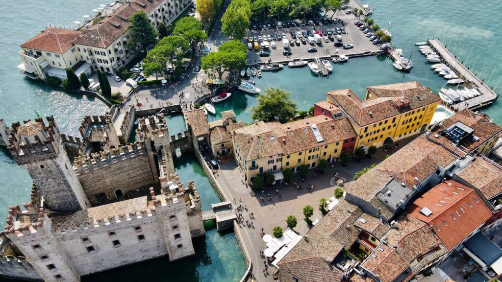Luftbild der Altstadt von Sirmione mit Scaligerburg, Hafen und Piazza